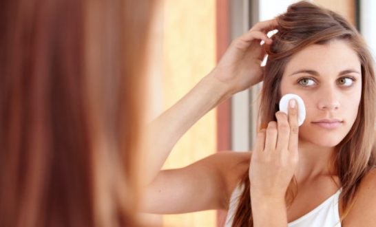 A beautiful young woman cleaning her face